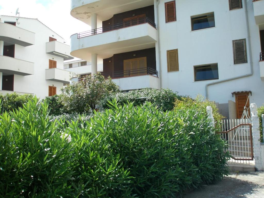 a building with a bunch of bushes in front of it at Appartamento Complesso Maresol in Falerna Marina