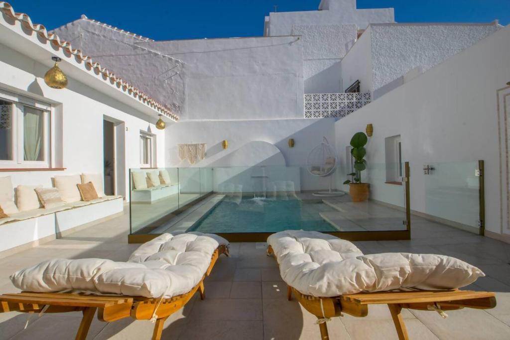 a house with a swimming pool and some chairs at Casa Marinero beach 2 in Torrox Costa