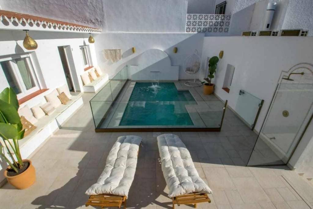 basen z dwoma leżakami przed pomieszczeniem ze szkłem w obiekcie Casa Marinero beach 1 w mieście Torrox Costa