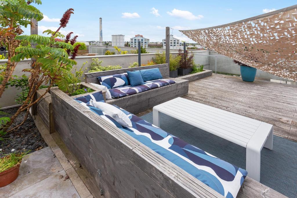 a rooftop patio with a couch and a hammock at Jardin du 8e Ciel - Neuf & Central in Nantes