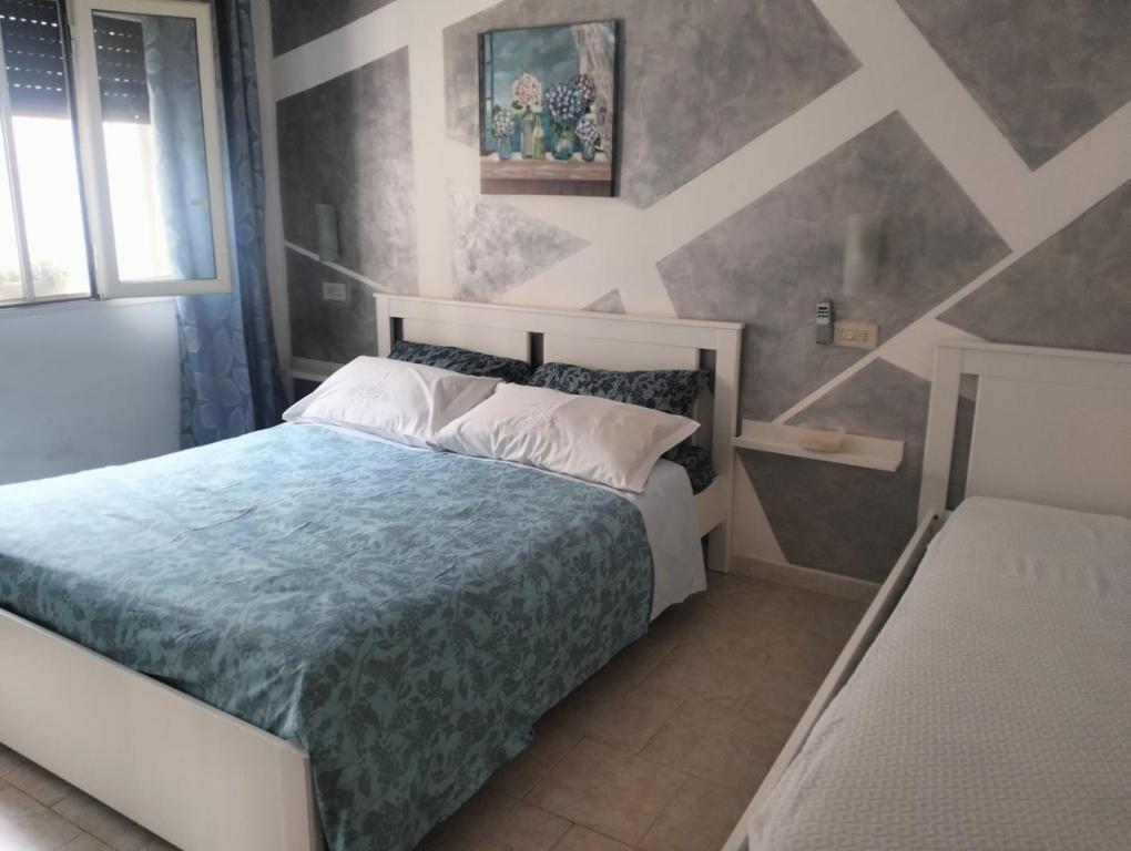a bedroom with a bed with a blue comforter at Casa MaryGiò in San Pietro in Bevagna