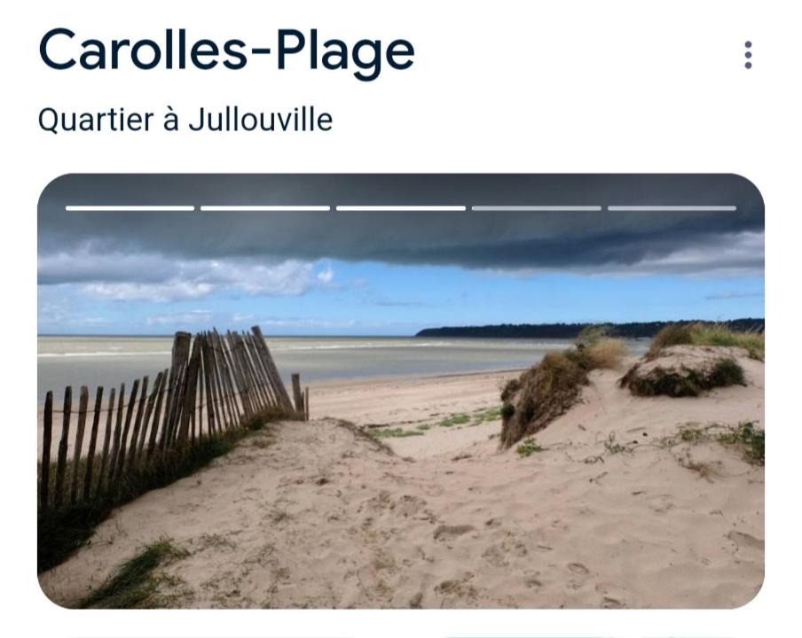 une plage de sable avec une clôture et l'océan dans l'établissement L'escapade, à Carolles