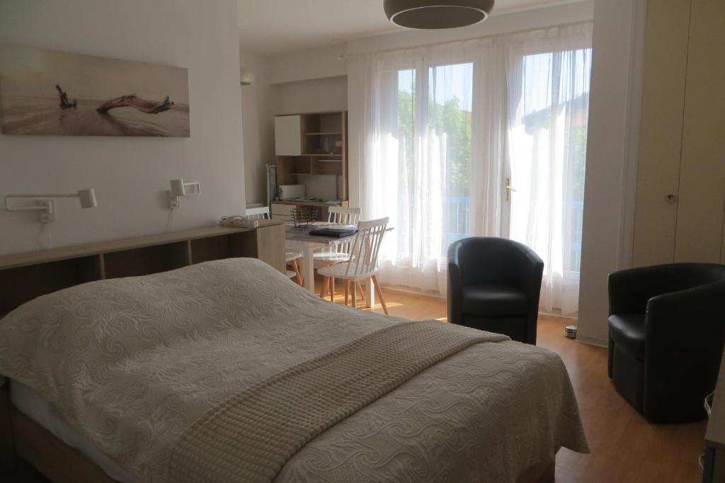 une chambre avec un lit, une table et des chaises dans l'établissement Chez Amélie Studio 2 Etoiles 50m des Thermes, à Amélie-les-Bains-Palalda
