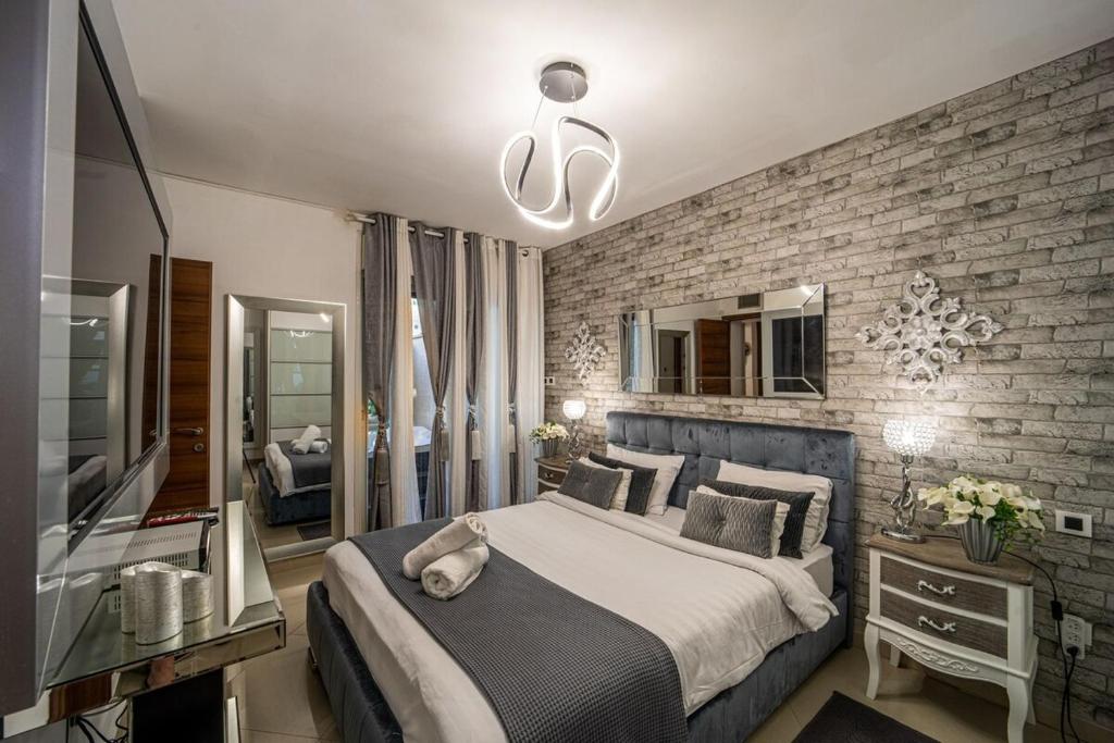 een slaapkamer met een groot bed en een bakstenen muur bij Garden Beach Luxury Apartment in Eilat