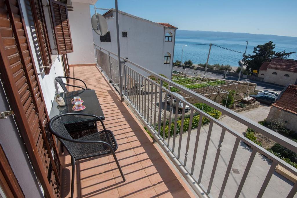 a balcony with a table and chairs and the ocean at Zara apartma in Podstrana