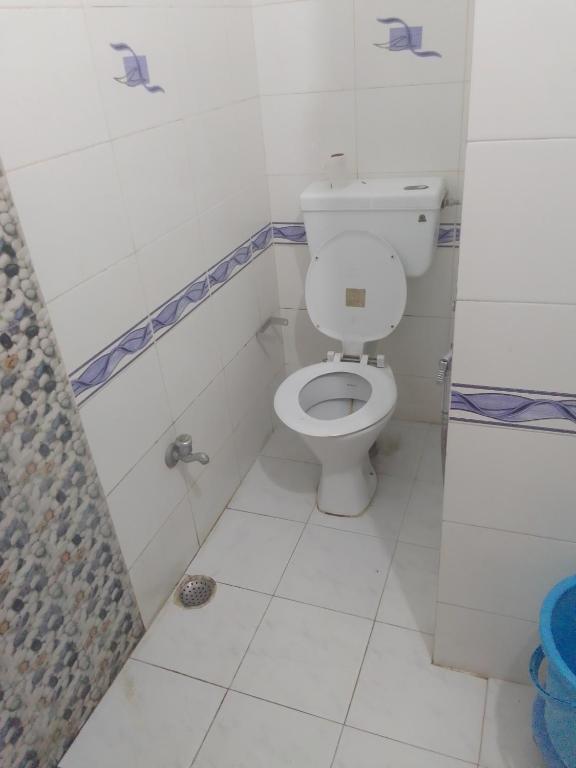 a white bathroom with a toilet and a shower at ZoukStayz in Rishīkesh