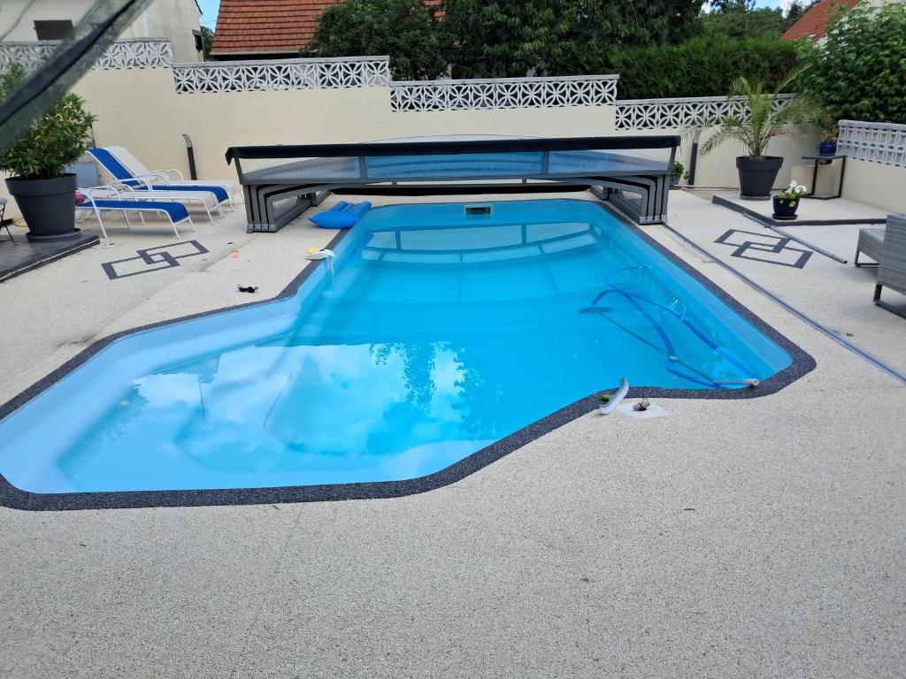 - une piscine d'eau bleue dans une terrasse dans l'établissement Logis de Paty, à Lagny-sur-Marne