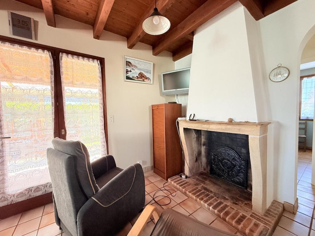 - un salon avec une chaise et une cheminée dans l'établissement Le repos du Goeland - 8 personnes, à Dolus-d'Oléron