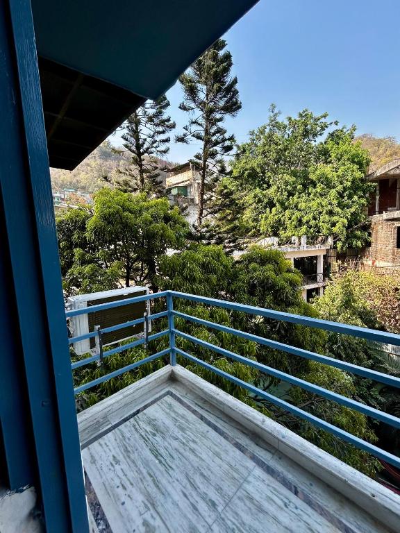 a balcony of a house with a blue railing at ZoukStayz in Rishīkesh