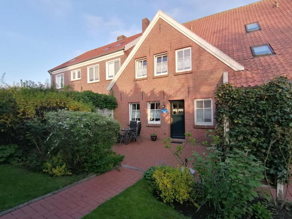 a brick house with a patio in front of it at Haus Tenne in Krummhörn