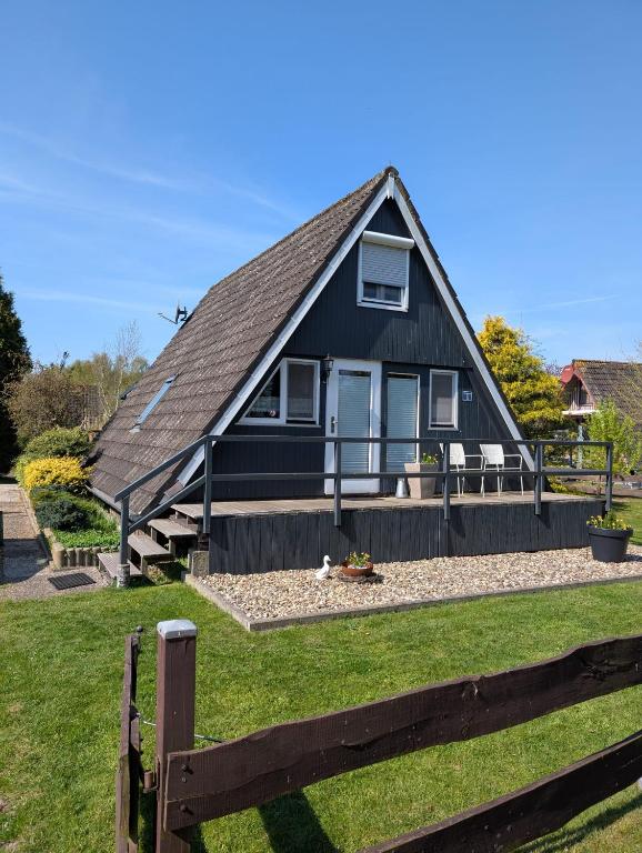 a black house with a fence in front of it at Ferienhaus Brungers in Südbrookmerland