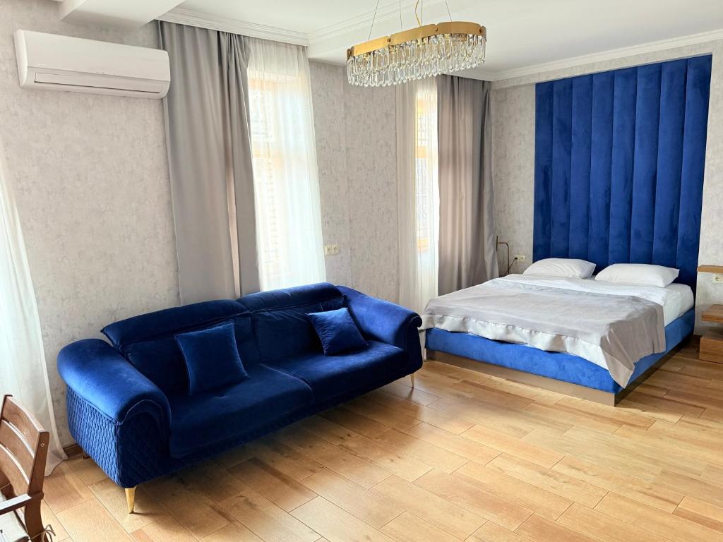 a bedroom with a bed and a blue couch at Boutique Hotel Tbili in Tbilisi City