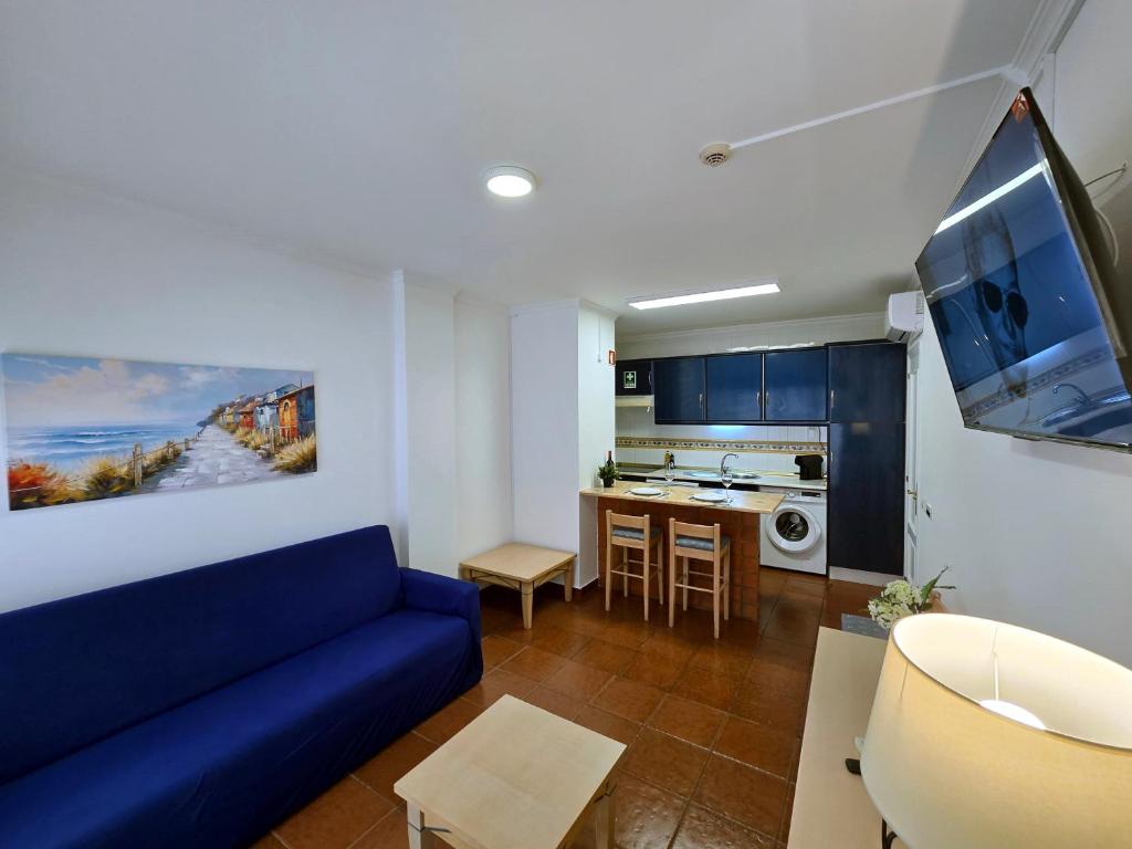 a living room with a blue couch and a kitchen at Monte Treasure - Beach, Wifi, Pool, Parking in Monte Gordo