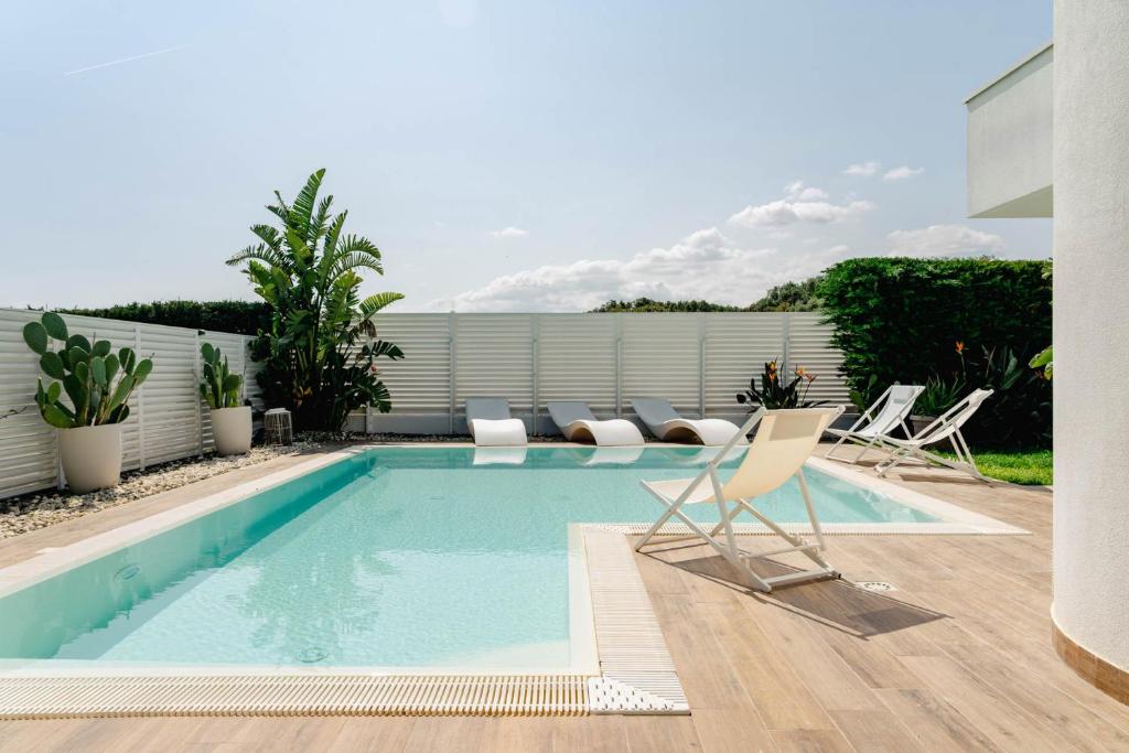 a swimming pool with lounge chairs and a swimming pool at Villa Luce Luxury Accomodation in Polignano a Mare