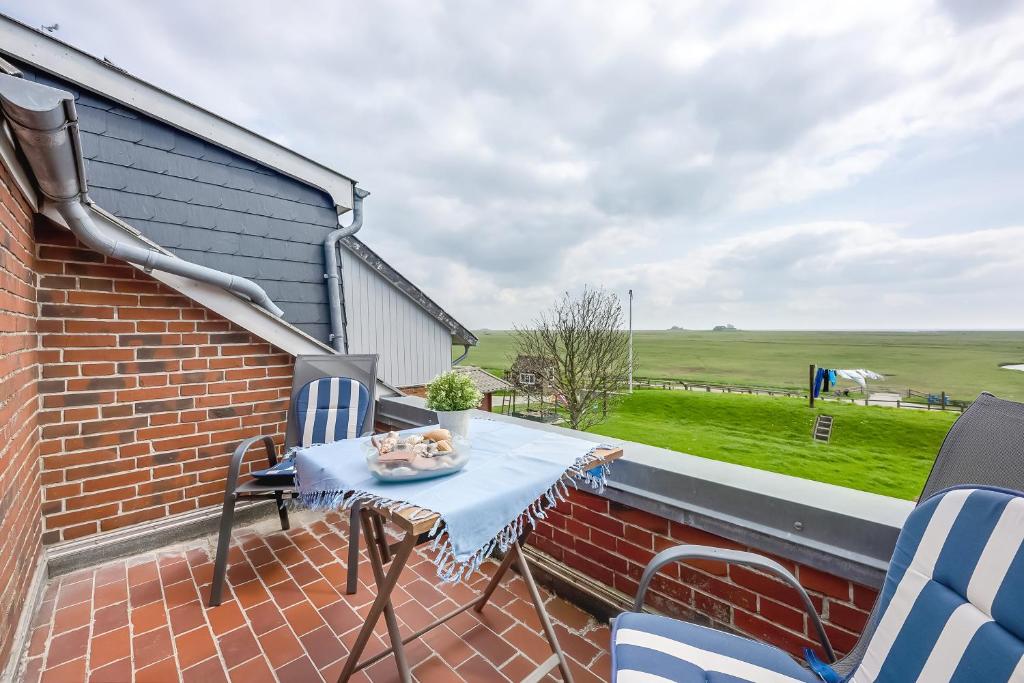 un patio con mesa y sillas en un edificio de ladrillo en Wohnung Hallighof, en Honkenswarft