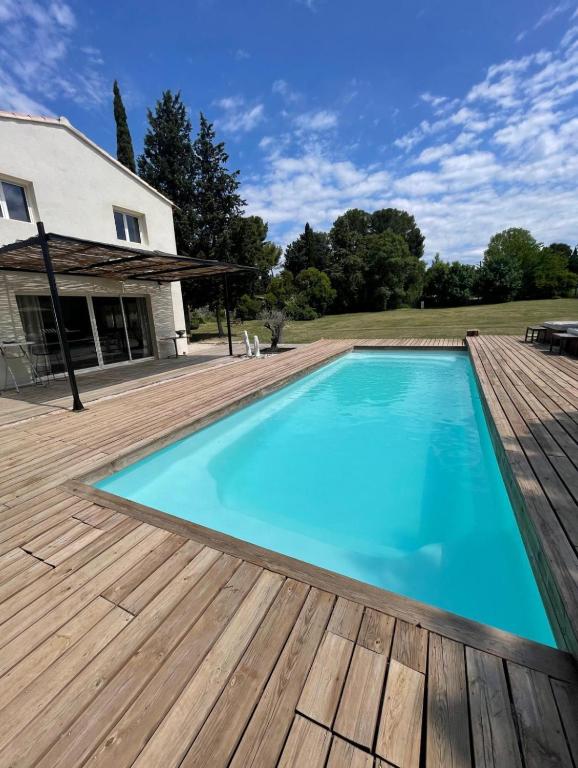 une grande piscine sur une terrasse en bois dans l'établissement Villa AKOA, à Aix-en-Provence