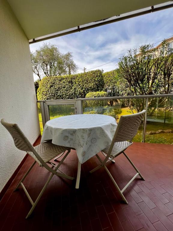 une table et deux chaises sur une terrasse dans l'établissement Parc Montfleury, à Cannes