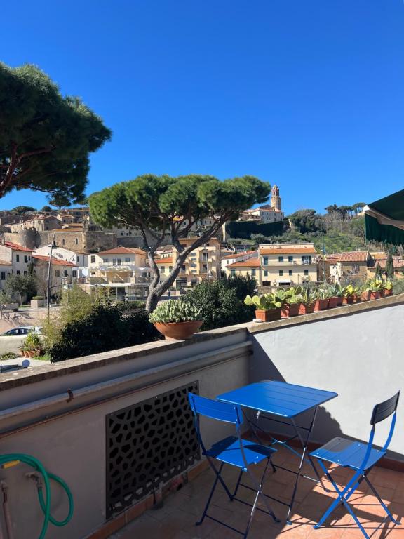a blue table and chairs on a balcony with a view at Cav Casa Brunella in Castiglione della Pescaia