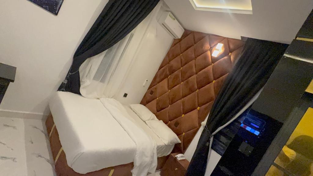 a small room with a bed and a window at Smart Luxury Apartments & Suites in Port Harcourt