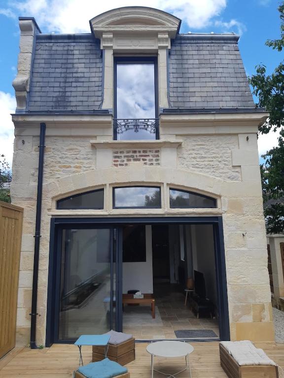une maison avec de grandes portes vitrées et un toit dans l'établissement Maison de charme face au Canal, à Caen