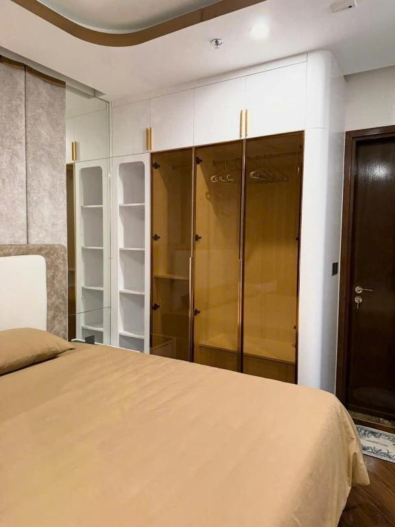 a bedroom with a bed and some glass closets at Cozy Homestay Diamond Crown Hải Phòng in Ðông Khê