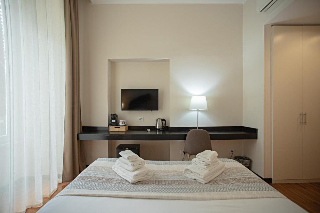 um quarto de hotel com uma cama e uma secretária em OperaDreams2 em Roma