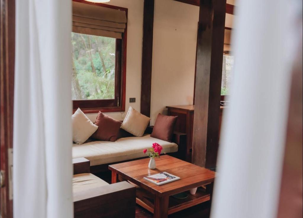 a living room with a couch and a table at Ru doi Camping mien tay in Kon Rung (1)