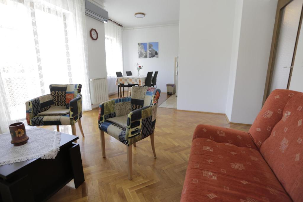 a living room with a couch and chairs and a table at Apartman Ljubica in Punat