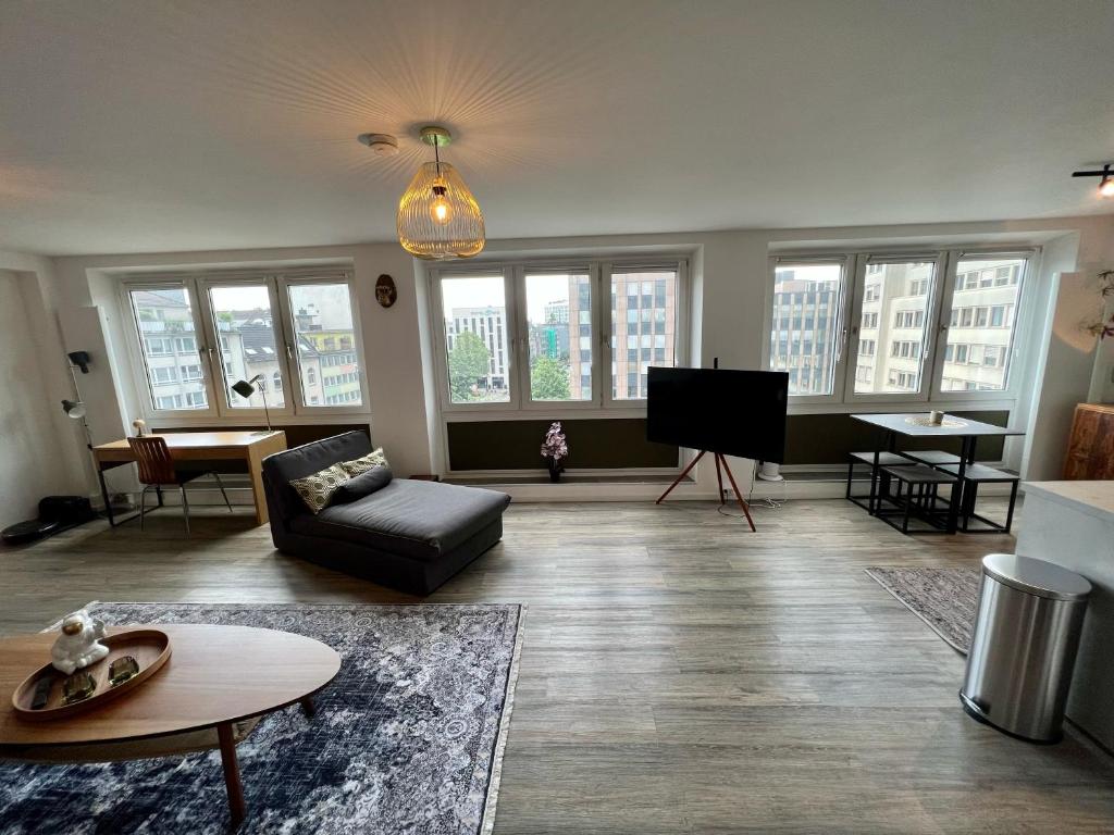 a living room with a couch and a tv at Stillvolles Apartment mitten in little Tokyo in Düsseldorf