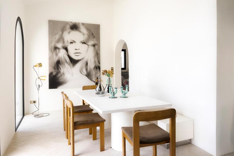 ein Esszimmer mit einem weißen Tisch und Stühlen in der Unterkunft Villa sur la plage Cap Corse in Brando