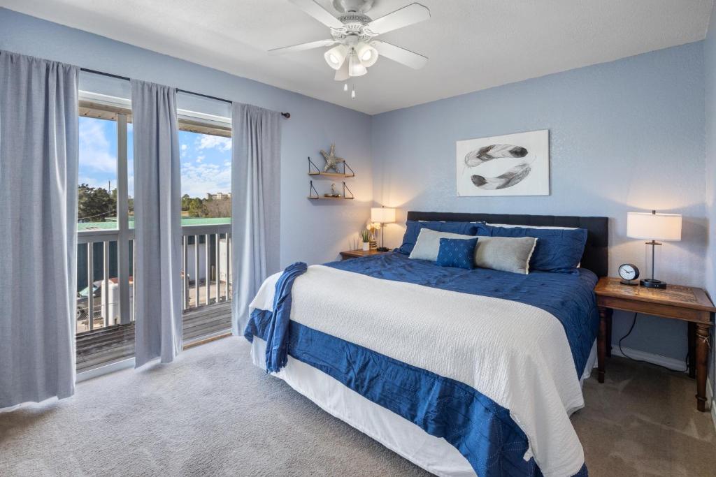 a blue bedroom with a bed and a balcony at Kate's Place - 13554 Perdido Key Drive in Pensacola