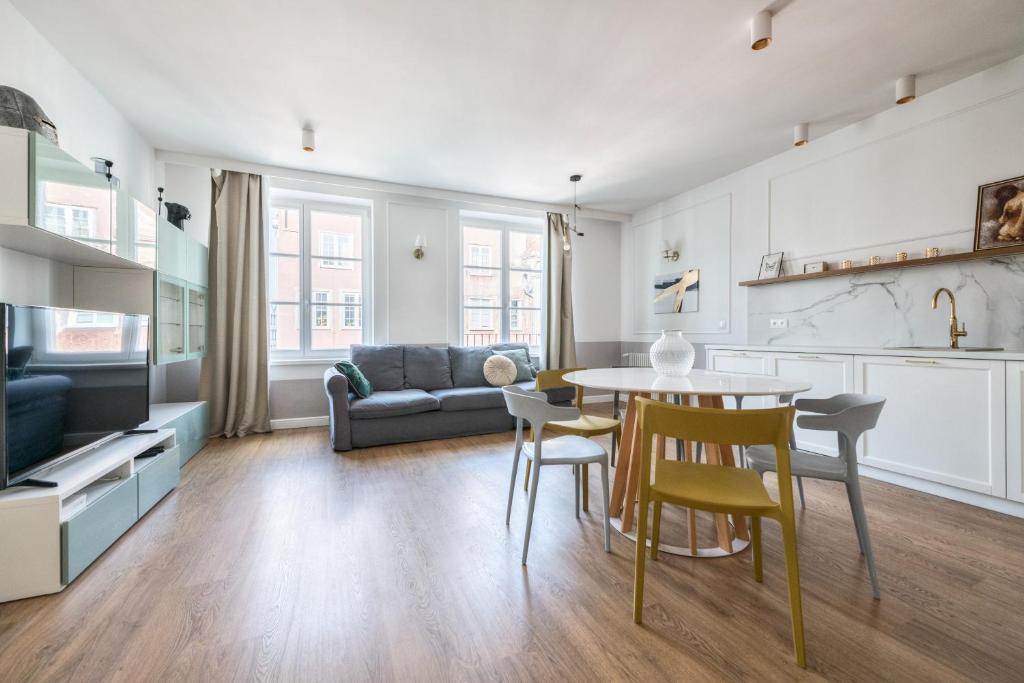 a kitchen and living room with a table and chairs at Old Town Długa by NorthSide Apartments in Gdańsk