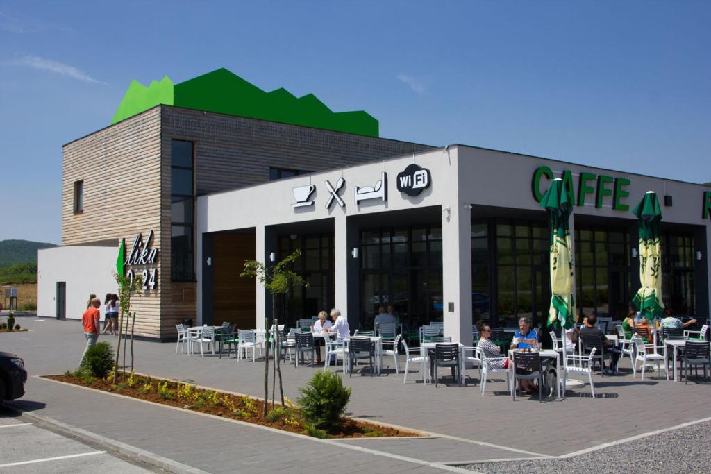 a building with people sitting at tables outside of it at Hotel Lika Jug in Brinje