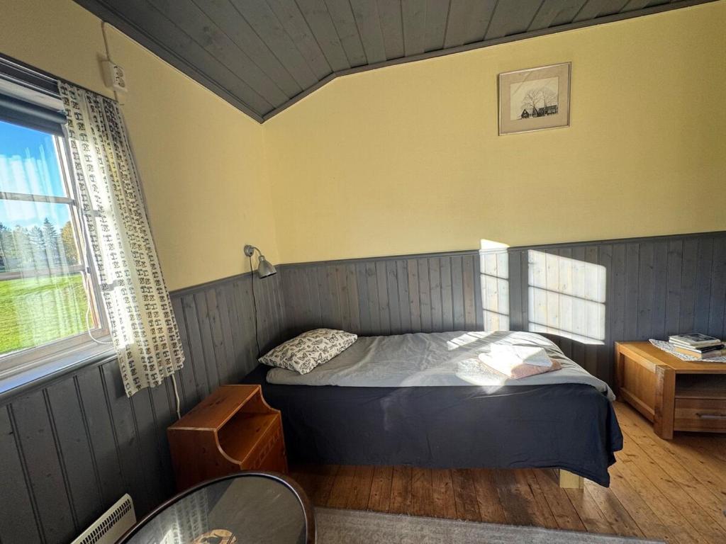 une chambre avec un lit, une table et une fenêtre dans l'établissement Cottage in quiet natural surroundings, à Ramsjö