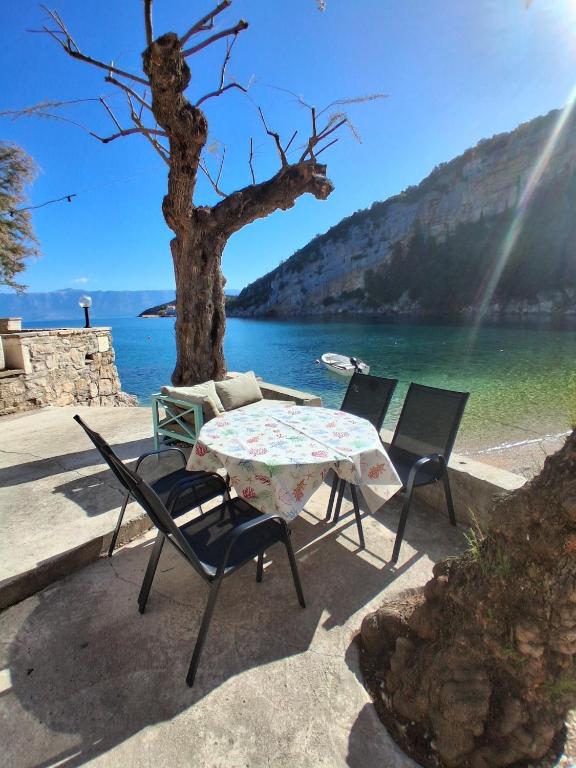 a table and chairs sitting next to a lake at Apartment Maestrol in Zastražišće