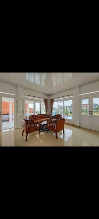 - un grand salon avec deux bancs et des fenêtres dans l'établissement Villa Istana Fitri, à Situ 2