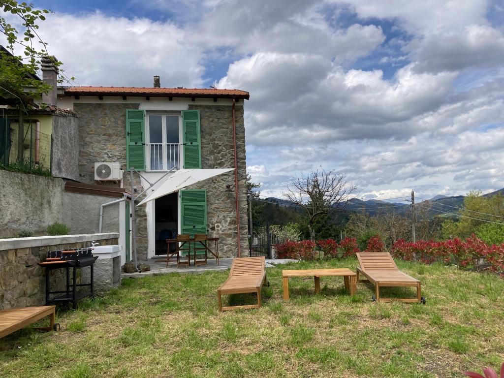 a house with two chairs and a table in the yard at Casa Vanna in Carrodano Superiore