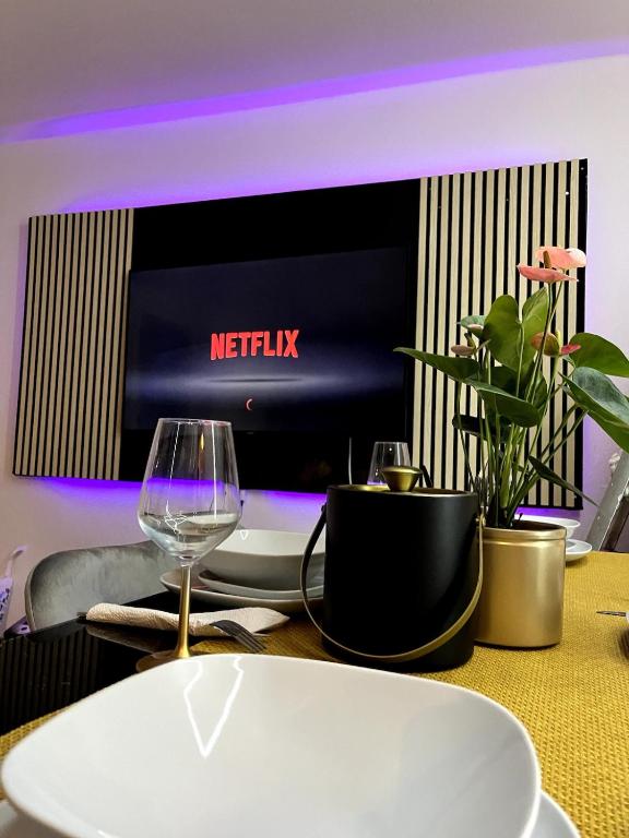 a table with a wine glass and a tv at Penthouse, Sonnenbalkon, Netflix in Saarbrücken