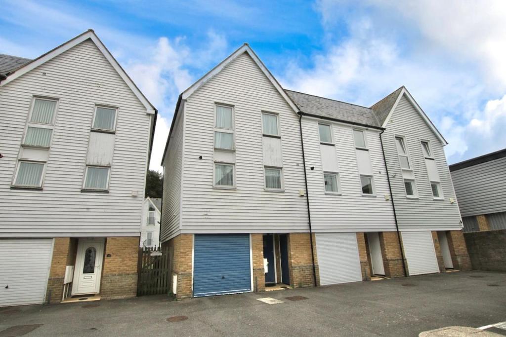 a large white house with a blue garage at The Dover House with river and Castle views in Dover