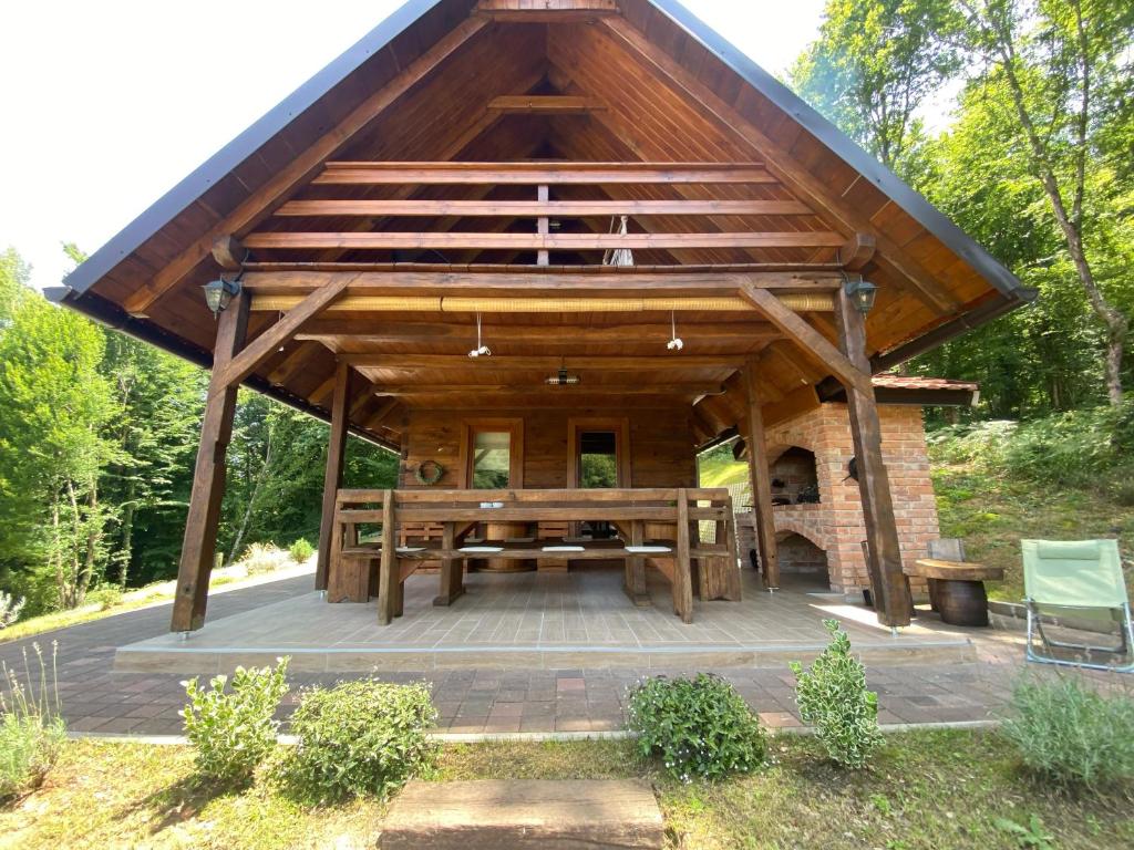 a pavilion with a picnic table and a fireplace at Kuća za odmor Foresta in Ladvenjak