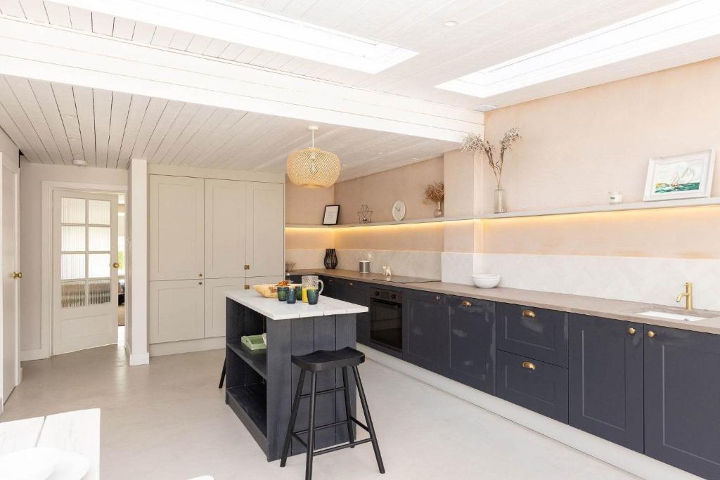 a kitchen with navy blue cabinets and a counter at Chic Coastal Retreat - 5-Min Stroll to Beach in West Wittering