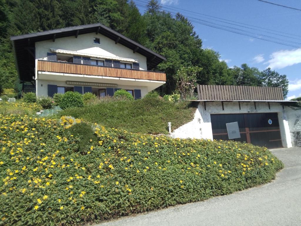 une maison sur une colline avec un champ de fleurs jaunes dans l'établissement A 5 minutes d ' ANNECY T2 dans maison champêtre au calme, à Villaz