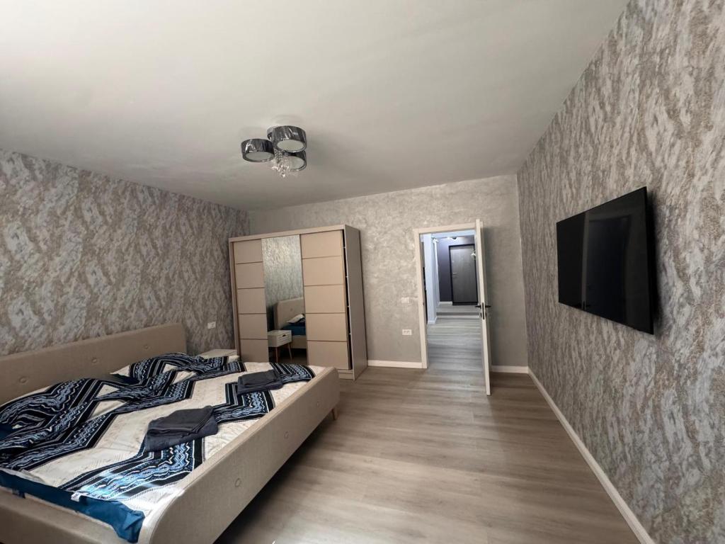 a bedroom with two beds and a flat screen tv at Studio Magheru Residence in Craiova