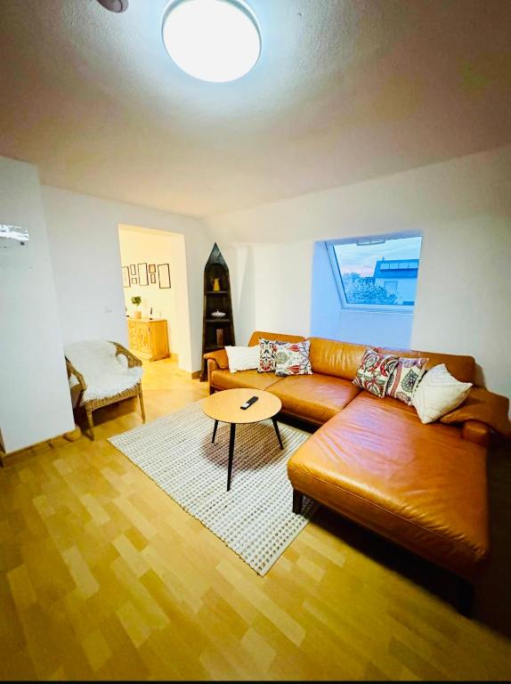 a living room with a leather couch and a table at Ferienwohnung ESMA in Burgau