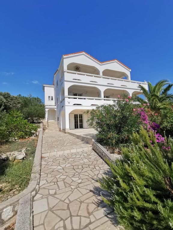 a large white building with a stone walkway at Villa Sunset in Mandre