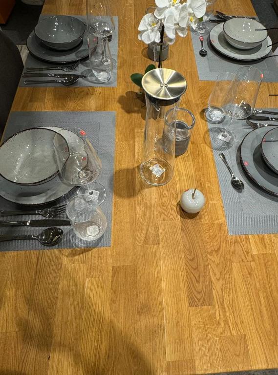 a wooden table with plates and glasses on it at Fewo Arthur am Elbtal in Meißen