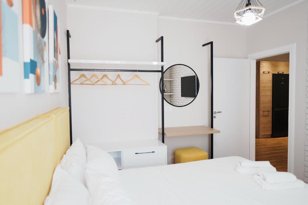 a bedroom with a white bed and a mirror at Luxury Apartment at Saranda Port in Sarandë