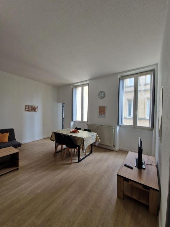 un salon avec une table et un canapé dans l'établissement Le Moulin hyper centre Libourne, à Libourne