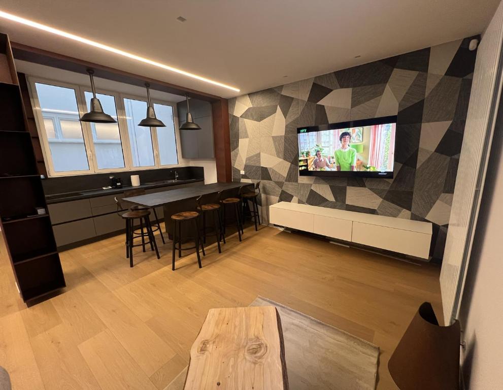 a living room with a table and a tv on a wall at Luxury Apartment, Downtown IMOLA, Italy in Imola