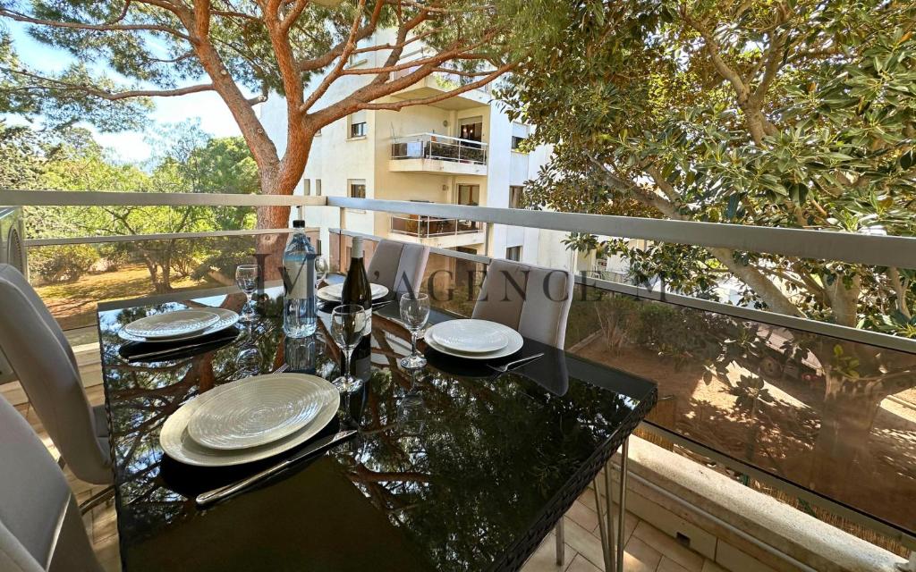 une table avec des assiettes et des verres sur un balcon dans l'établissement Studio Casa Vecchia, à Calvi
